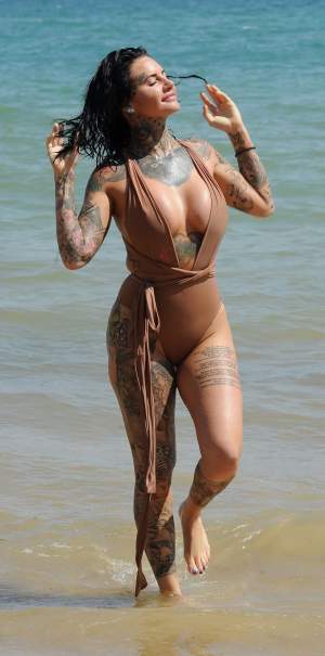 FOTO / E tatuată peste tot, e fierbinte și sânii îi ies din costumul de baie! Ea e femeia care lasă bărbații "paf"