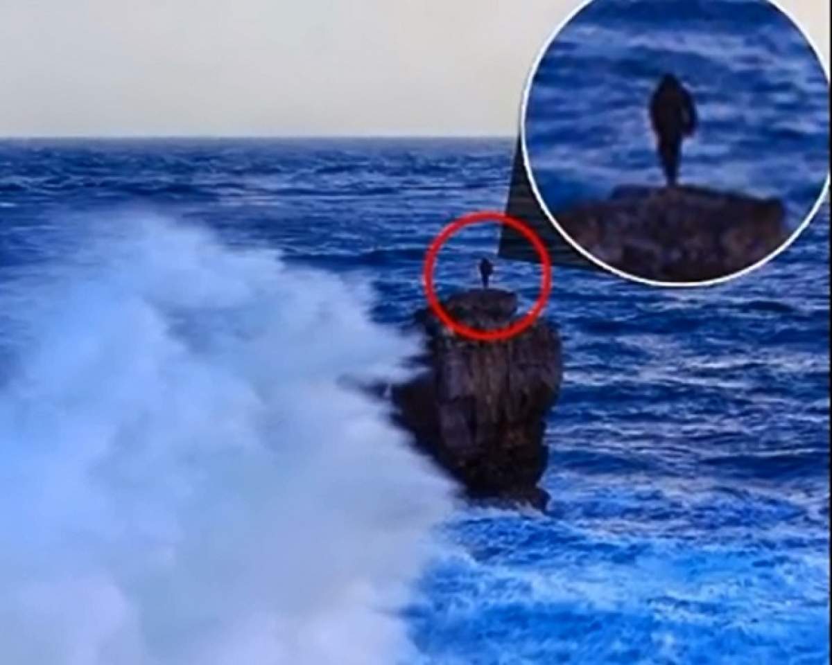 VIDEO / Curaj nebun! Un bărbat s-a urcat pe o stâncă de 15 metri, în timp ce valuri puternice se izbeau de ea