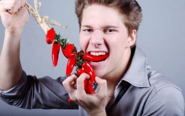 острый вкус. девушка ест перец чили. девушка с перцем. острый человек. парень с перчинкой.