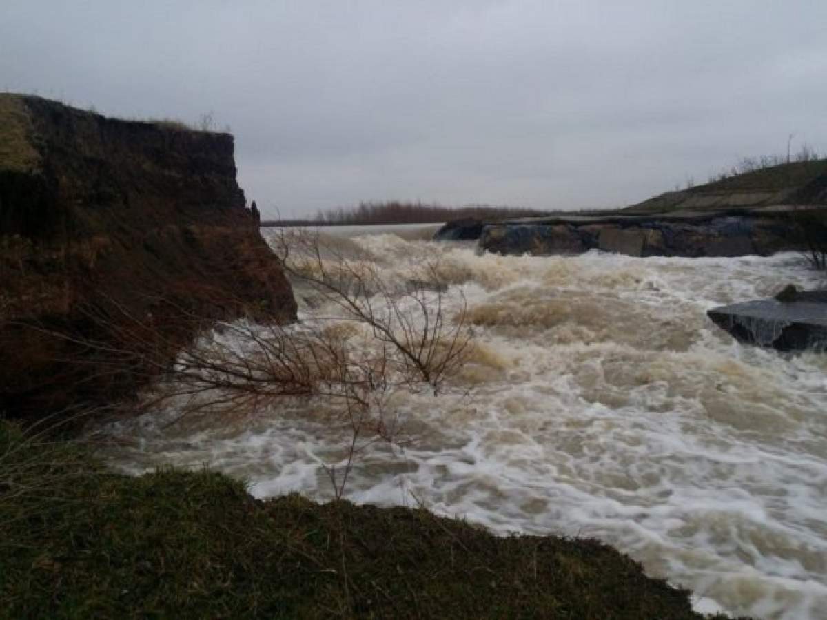 Imaginile groazei! Un baraj din Timiş s-a rupt în două şi a inundat terenurile din apropiere