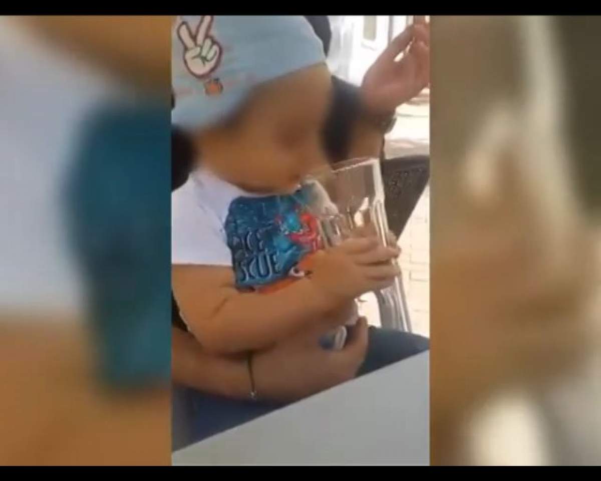 VIDEO / Clipul care a devenit INSTANT viral! Un bărbat îşi obligă copilul să bea alcool şi să fumeze!