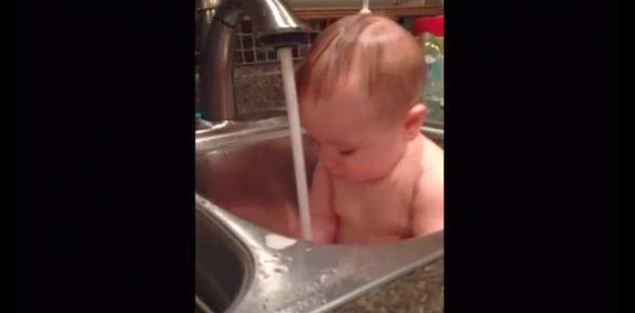 VIDEO / Ce drăgălaş este! Un bebeluş este luat prin surprindere de apa din chiuvetă