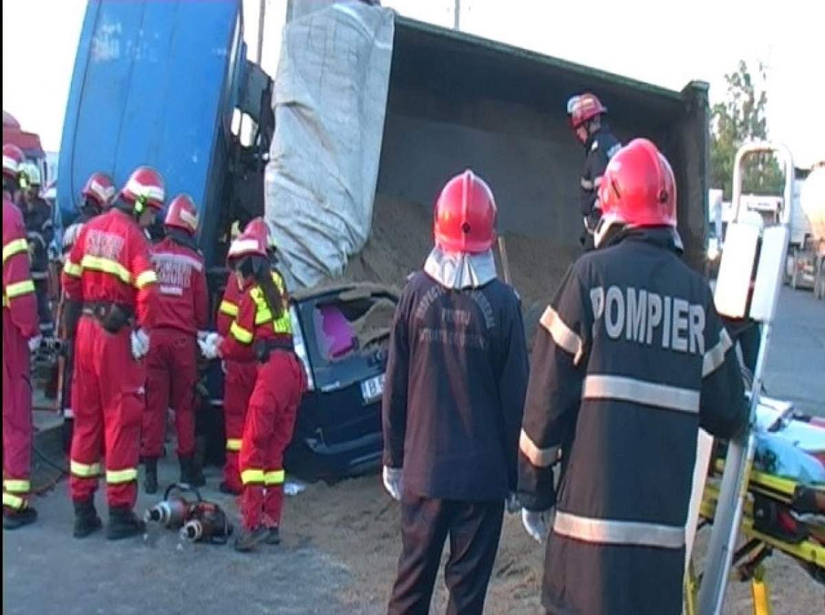 Atenţie! Imagini şocante! O basculantă plină cu nisip s-a răsturnat peste o maşină şi a omorât două persoane!