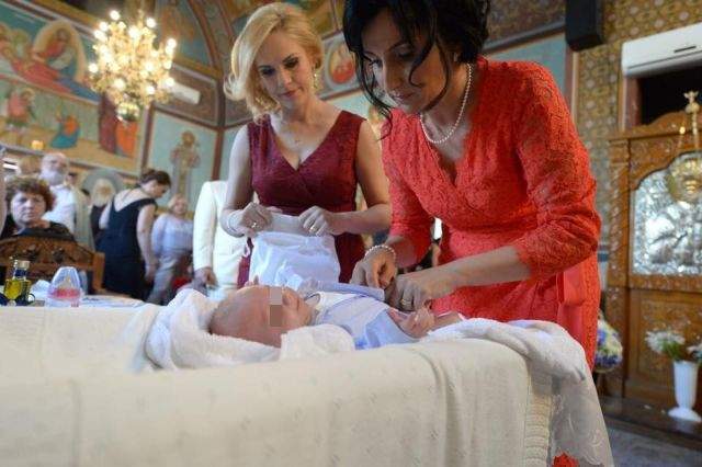 FOTO / Imagini din biserică de la botezul fiului Gabrielei Firea. Naşul Gigi Becali a fost extrem de emoţionat