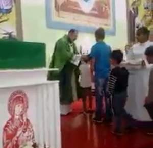 VIDEO HALUCINANT/ Bătaia e ruptă din RAI? Un preot, filmat în timp ce loveşte zeci de copii în faţa ALTARULUI!