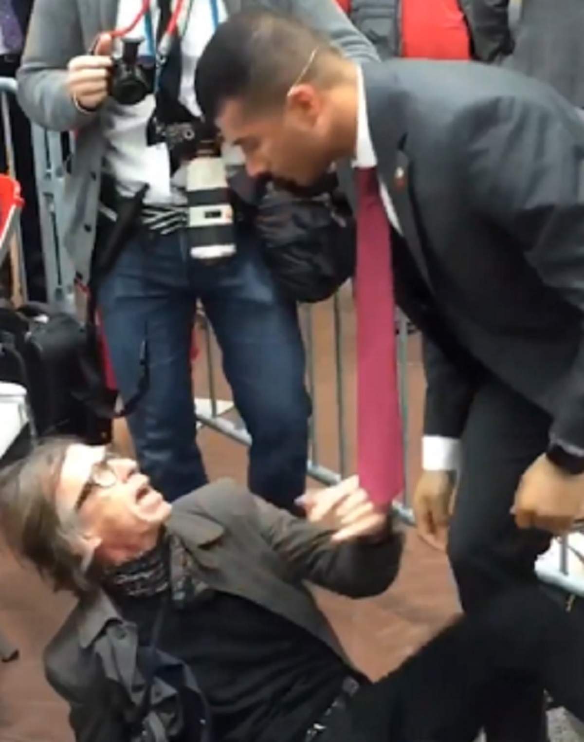 VIDEO / Imagini şocante de la un miting! Un fotograf a fost strâns de gât şi trântit la pământ