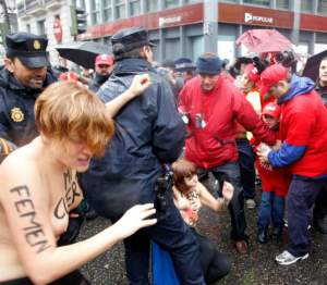 FOTO / În SÂNII GOI, activistele FEMEN s-au luat la bătaie cu poliţiştii, în timpul unui protest din Madrid