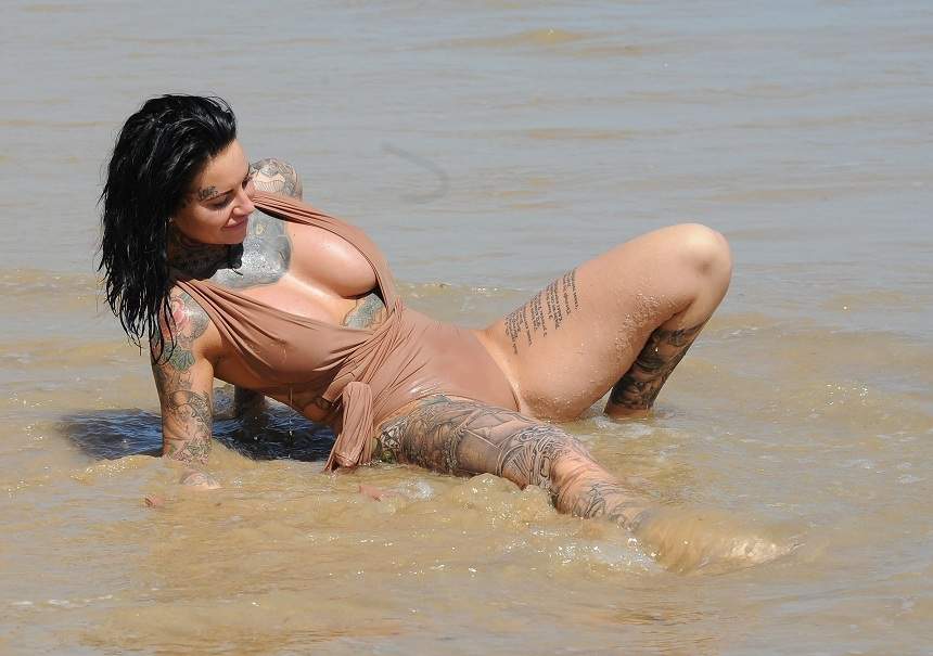 FOTO / E tatuată peste tot, e fierbinte și sânii îi ies din costumul de baie! Ea e femeia care lasă bărbații "paf"