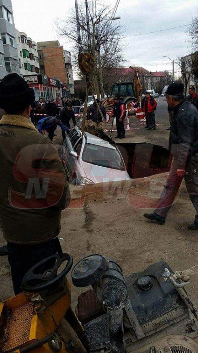 FOTO / Imagini incredibile în centrul oraşului! S-a trezit cu maşina într-un crater imens, după ce strada s-a surpat