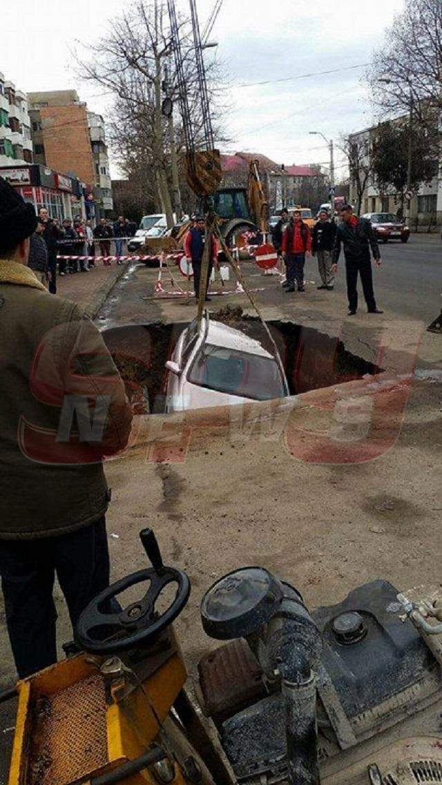 FOTO / Imagini incredibile în centrul oraşului! S-a trezit cu maşina într-un crater imens, după ce strada s-a surpat