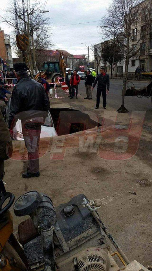 FOTO / Imagini incredibile în centrul oraşului! S-a trezit cu maşina într-un crater imens, după ce strada s-a surpat