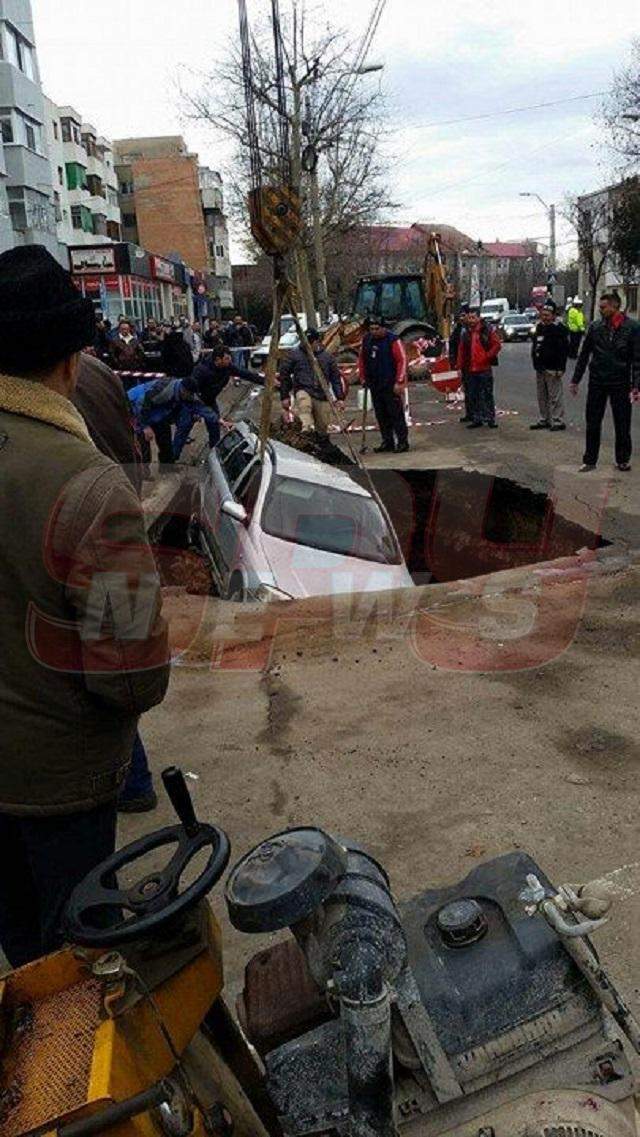 FOTO / Imagini incredibile în centrul oraşului! S-a trezit cu maşina într-un crater imens, după ce strada s-a surpat