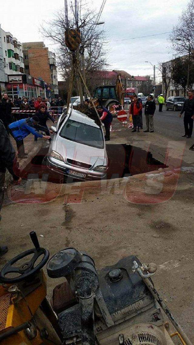 FOTO / Imagini incredibile în centrul oraşului! S-a trezit cu maşina într-un crater imens, după ce strada s-a surpat