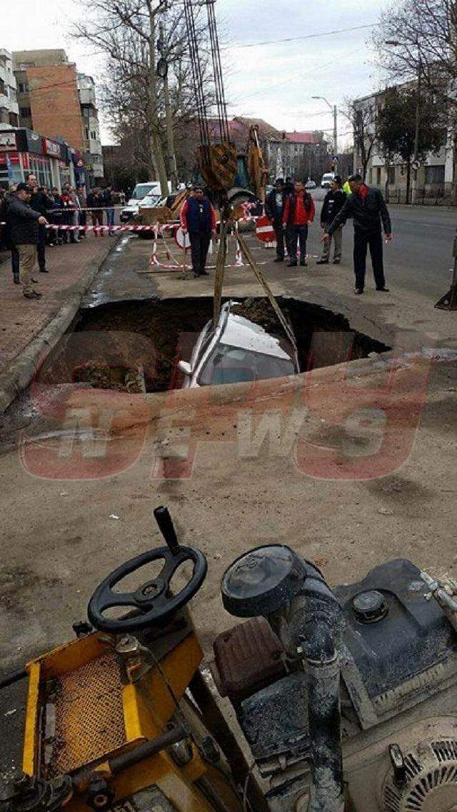 FOTO / Imagini incredibile în centrul oraşului! S-a trezit cu maşina într-un crater imens, după ce strada s-a surpat