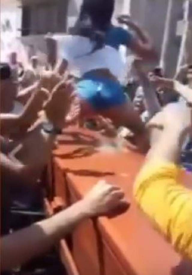 VIDEO / Să vezi și să nu crezi! A dansat lasciv pe un coșciug la înmormântare! Oamenii s-au înghesuit să o plesnească peste fundul obraznic