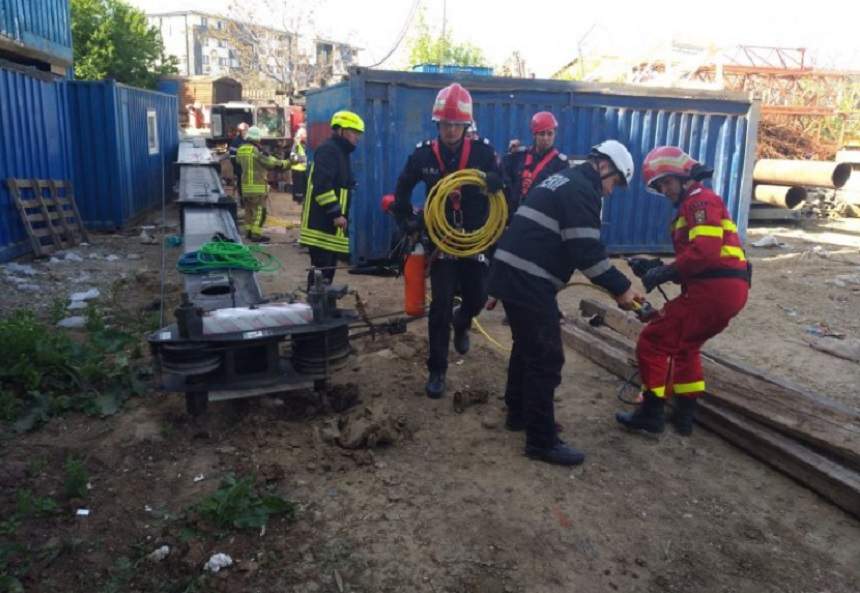 Situaţie de coşmar! O macara s-a răsturnat, iar un bărbat este prins sub un container, în Bucureşti