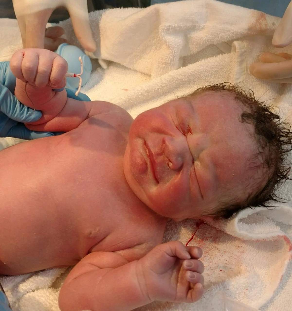 FOTO / Un bebeluş a fost fotografiat ţinând steriletul mamei în mână!