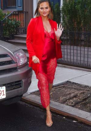 FOTO / Soţia lui John Legend arată fabulos cu burtica la vedere. Chrissy Teigen, apariţie de 10 într-o rochie roşie