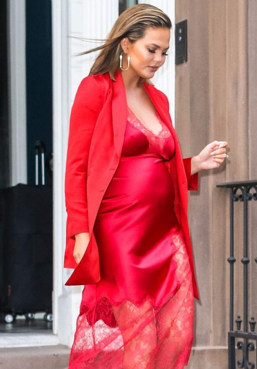 FOTO / Soţia lui John Legend arată fabulos cu burtica la vedere. Chrissy Teigen, apariţie de 10 într-o rochie roşie