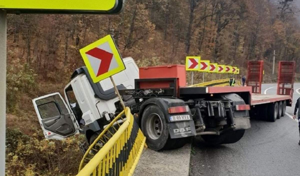 FOTO / Trafic blocat pe Valea Oltului! Un TIR stă să cadă peste calea ferată