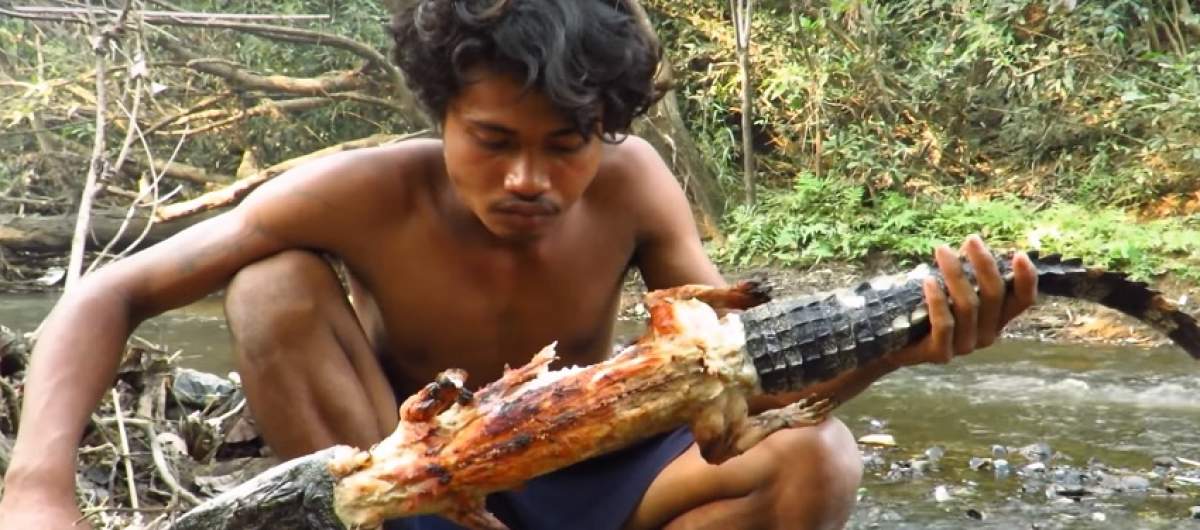 VIDEO / Teribil! Un bărbat mănâncă un crocodil după ce ''l-a vânat'' din râu