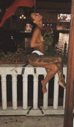 FOTO / Vedetă de reality show, pozată la balcon goală-pușcă, acoperită de un buchet de trandafiri: "Așa e când ești iubită"