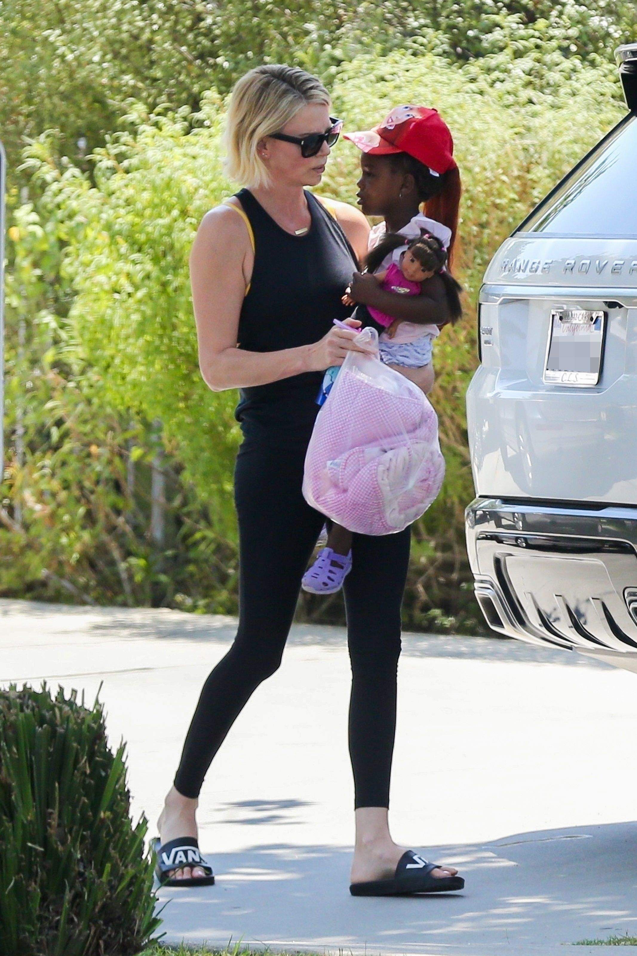 FOTO / Charlize Theron, la plimbare cu fetița, după ce a slăbit 20 de kilograme. S-a dus sex-simbolul de altă dată