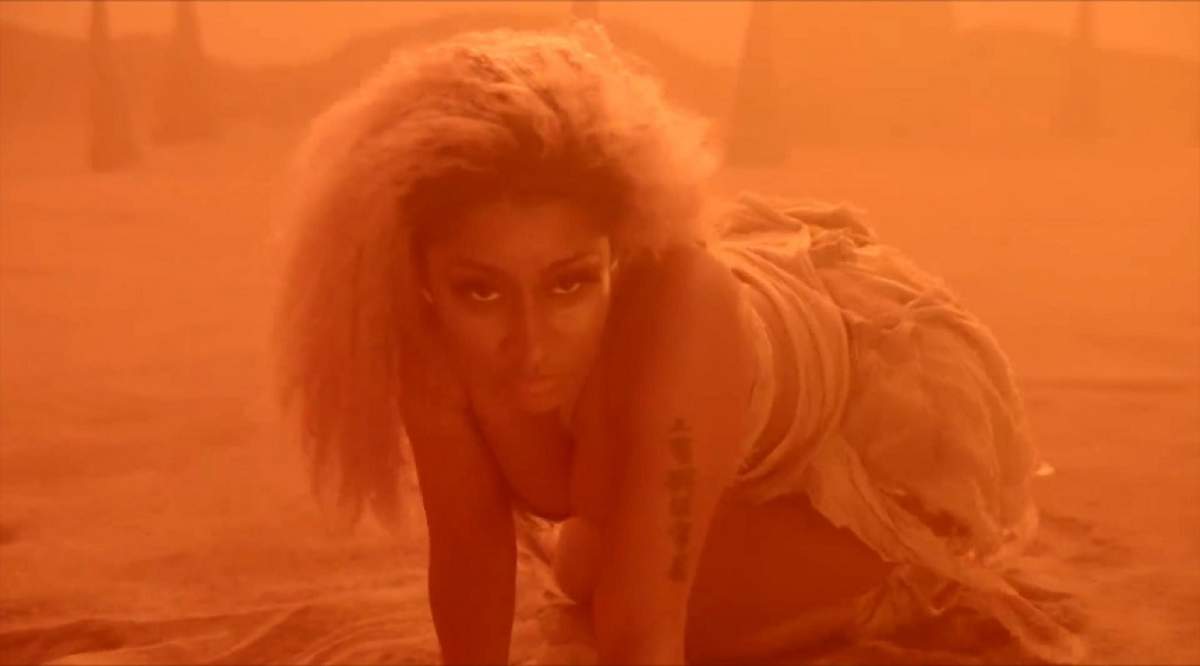FOTO / Nicki Minaj, tăvălită prin nisip, în patru labe! Artista și-a arătat sânii în toată splendoarea