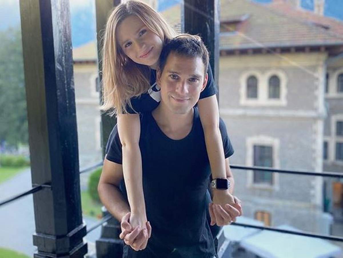 Cristina Ciobănașu și Vlad Gherman pe balcon. Cei doi se țin în brațe.