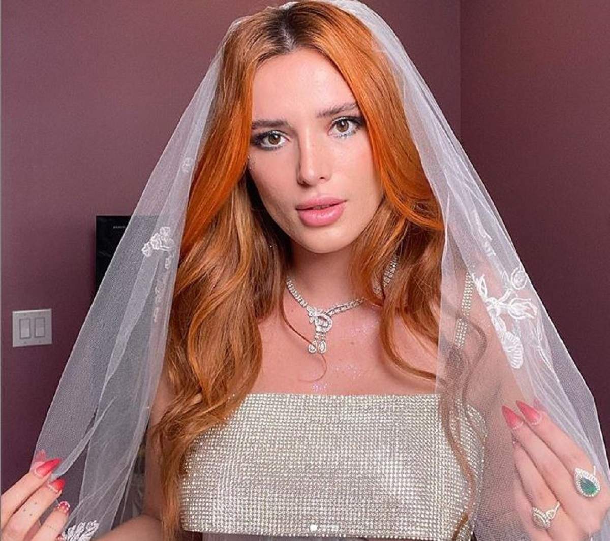 Bella thorne poarta un val pe cap, zambeste timid si i se vad bijuteriile stralucitoare