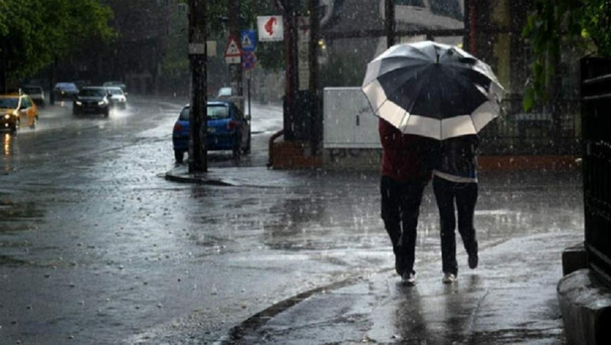Fotografie pe timp de ploaie cu două persoane sub o umbrelă
