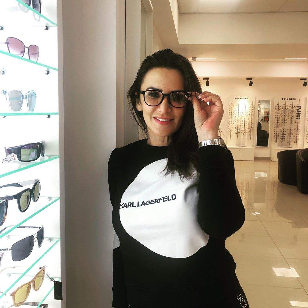 Mara Bănică în bluză neagră cu alb și ochelari.