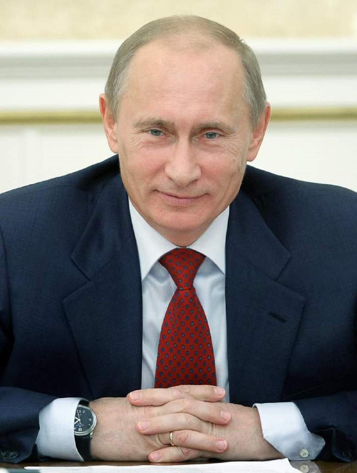 Vladimir Putin intr-o conferinta, poarta costum cu cravata rosie