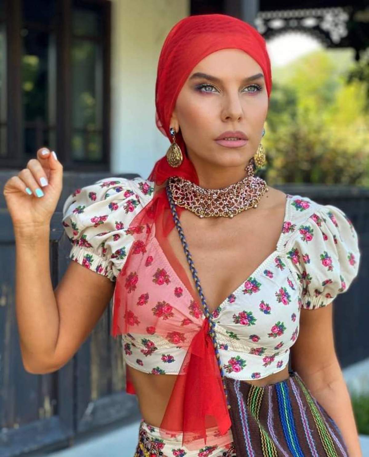 Anna Lesko poarta o esarfa rosie pe cap si are un top alb cu buline