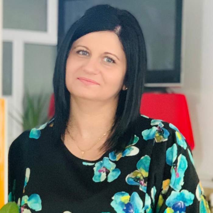 Mioara Neagu în rochie neagră cu flori albastre.