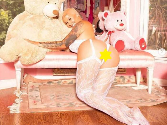 Amber Rose este in lenjerie intima alba si tine in brate un urs de plus