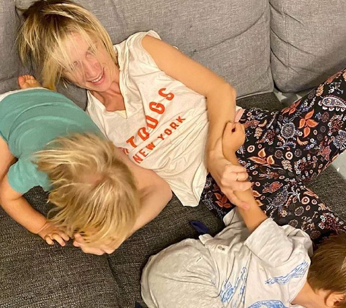 Adela Popescu se joacă cu fiii ei. Cei trei se află pe canapea.