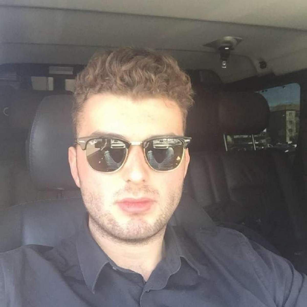 Victoraș Micula se află în mașină. Milionarul poartă ochelari de soare.