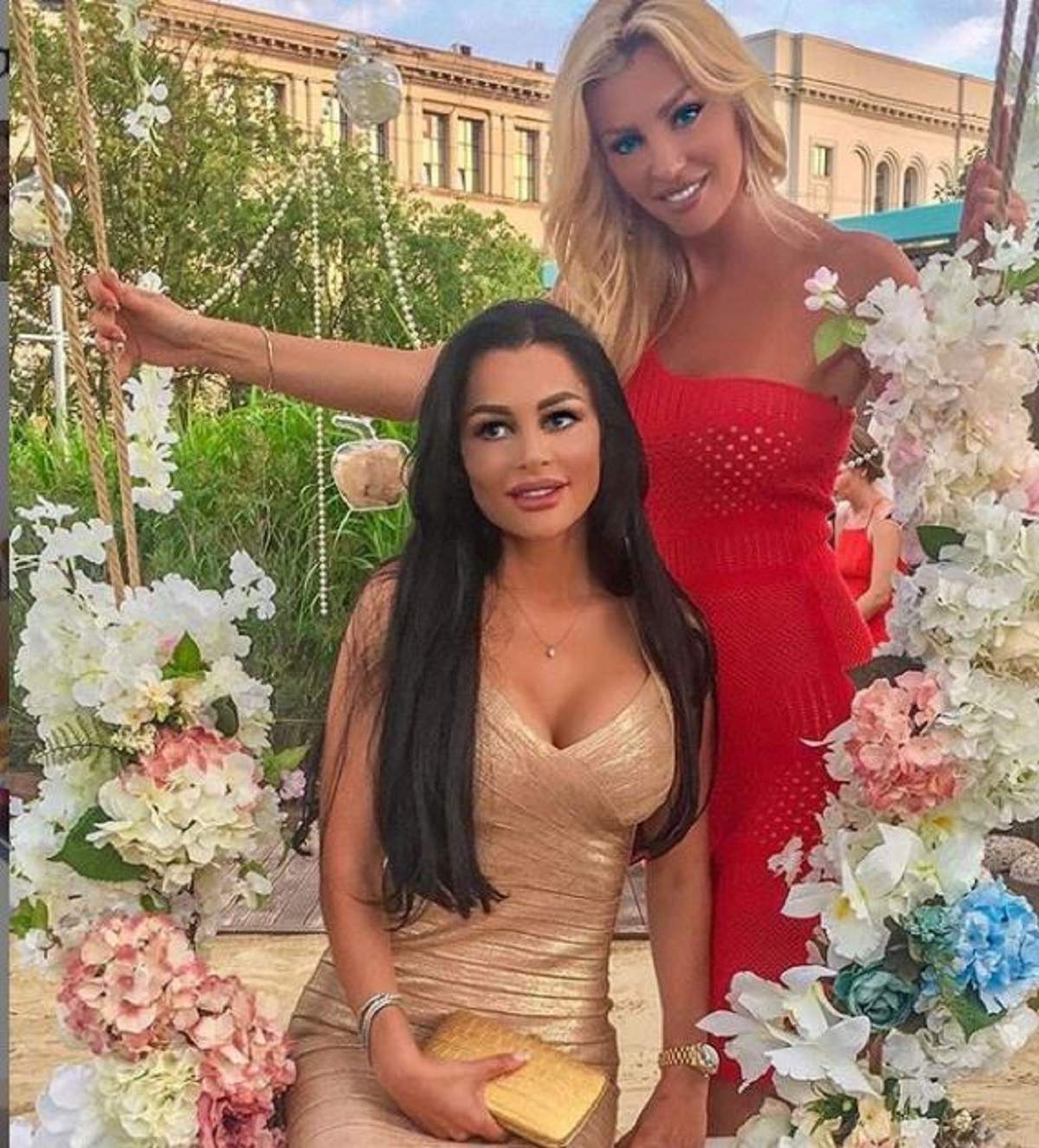 Brigitte si Cristina sunt imbracate elegant si stau pe un leagan ornat cu flori