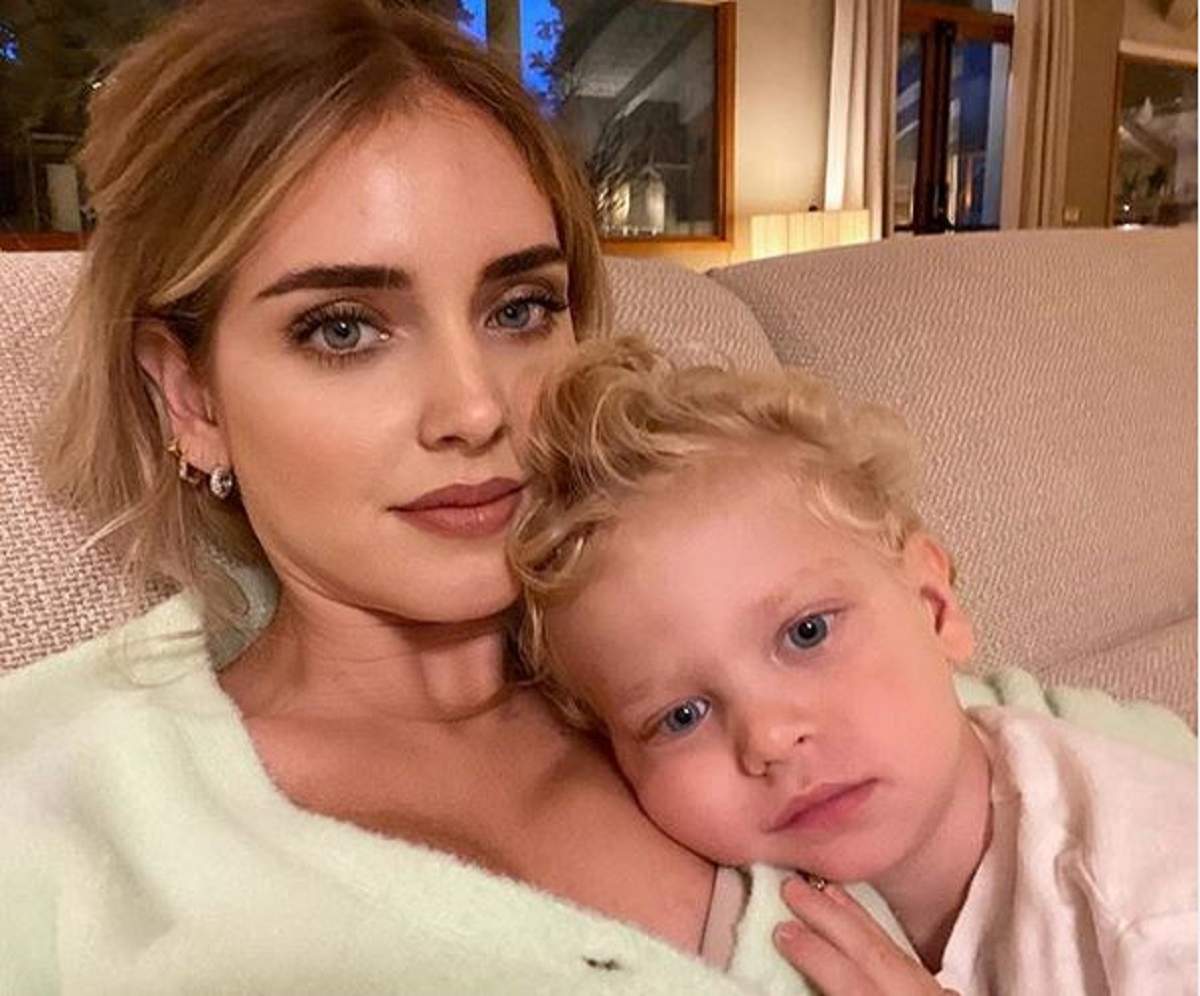 Chiara Ferragni stă pe canapea alături de fiul ei, Leo. Cei doi poartă tricouri albe.