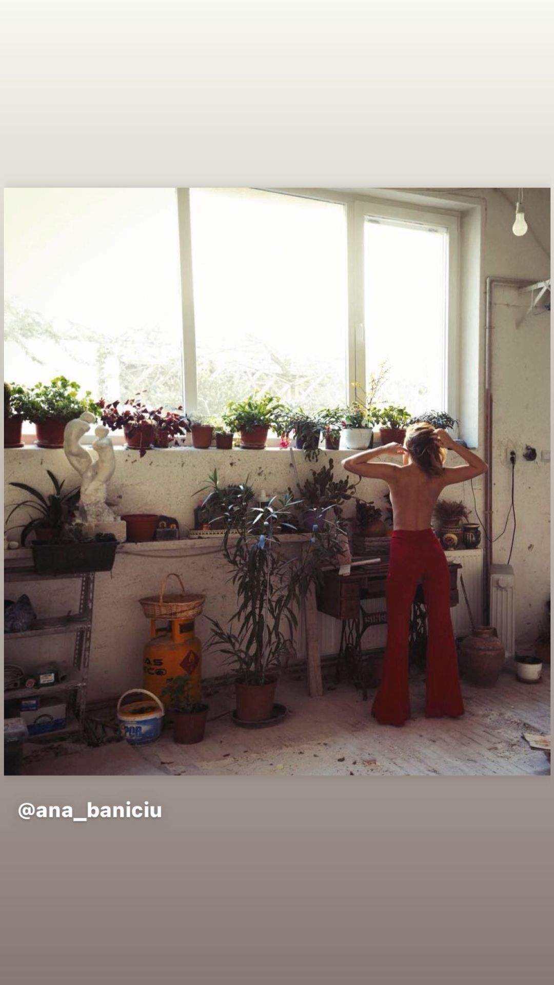 Ana Baniciu s-a fotografiat la geam, lângă mai multe flori, fără bluză pe ea