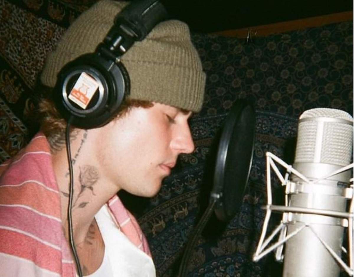 Justin Bieber este la studio, are un fes verde in cap, castile pe urechi si inregistreaza