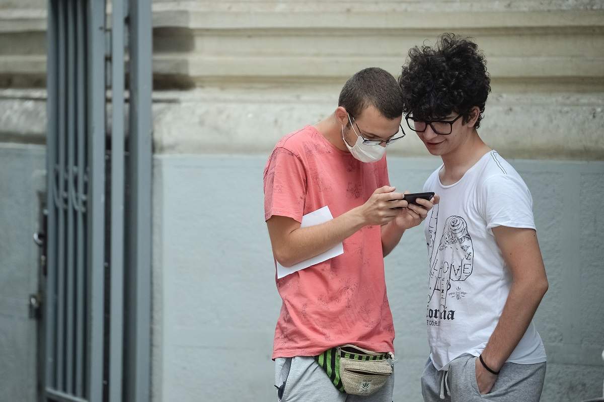 Doi tineri verifica rezultatele la examenul de bacalaureat, cu ajutorul telefonului, pe site-ul http://bacalaureat.edu.ro/, in Bucuresti, marti, 30 iunie 2020
