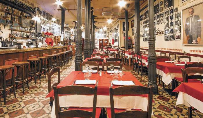 Interior restaurant cu bar și mese cu față de masă roșie