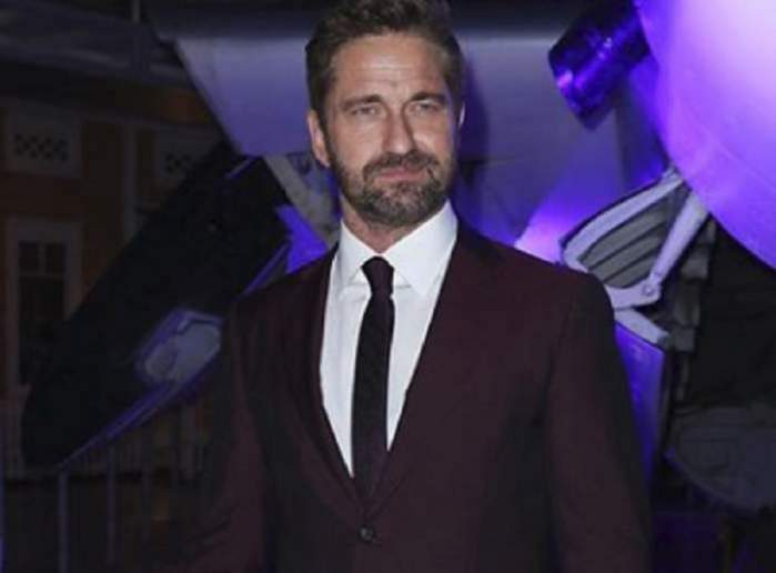 Gerard Butler este imbracat la costum, la un eveniment public