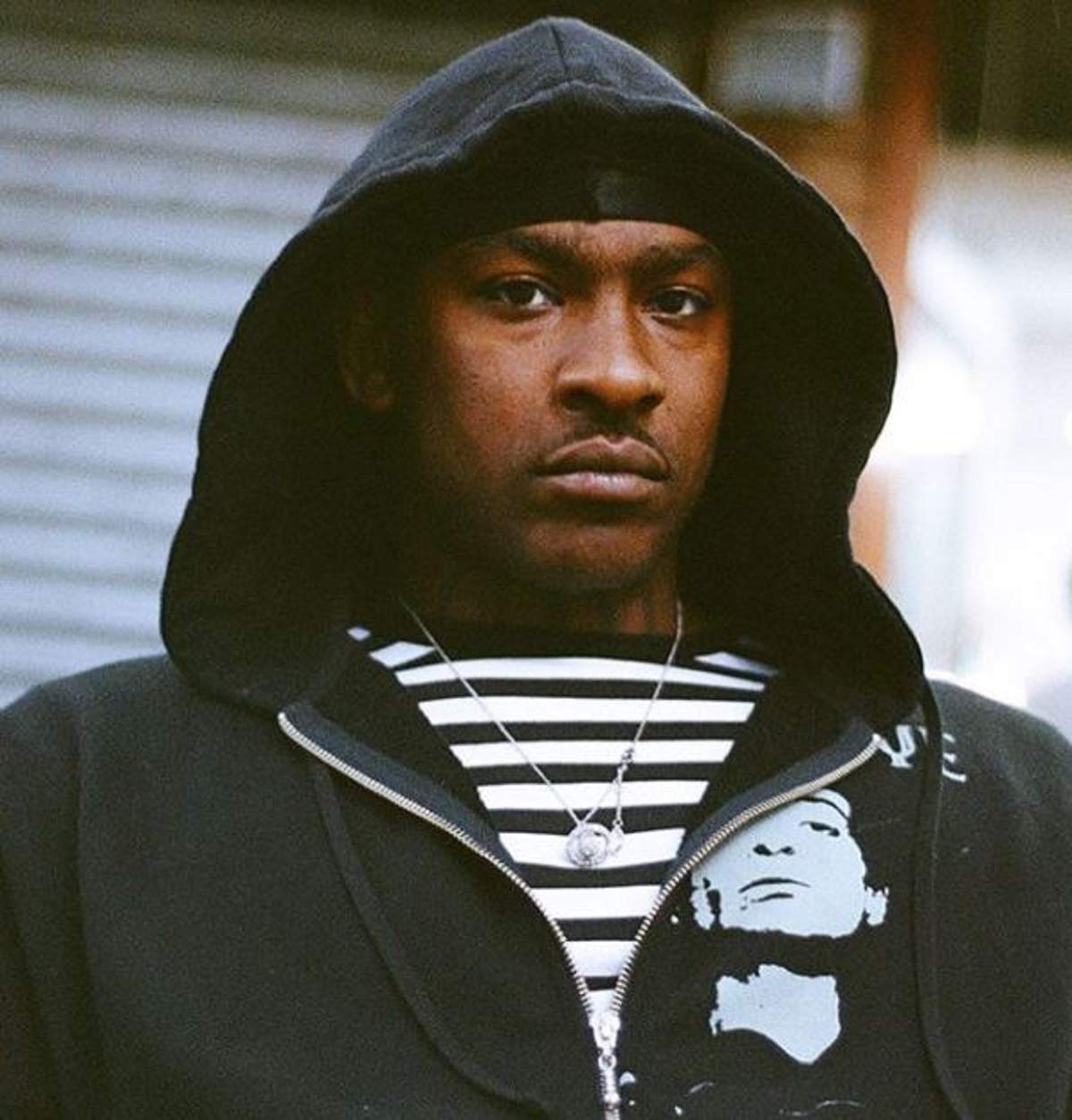 Skepta poarta un hanorac negru, cu glug in cap