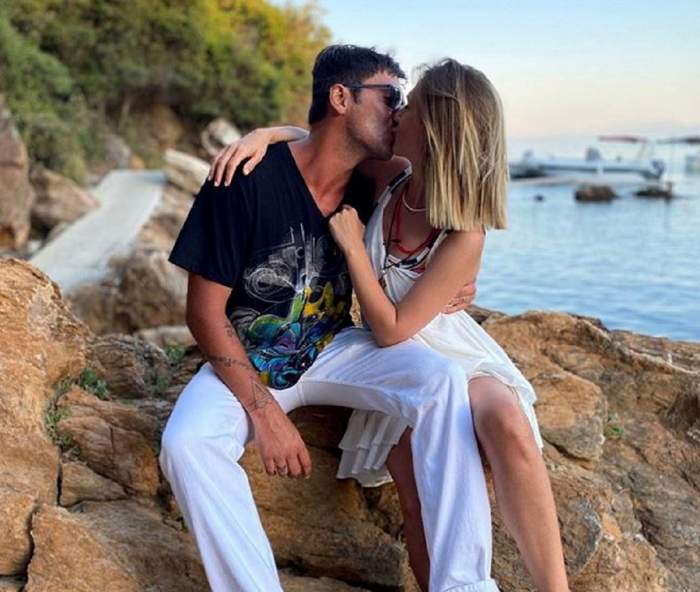 Adela Popescu și Radu Vâlcan se sărută cu patos. Cei doi stau pe o stâncă.
