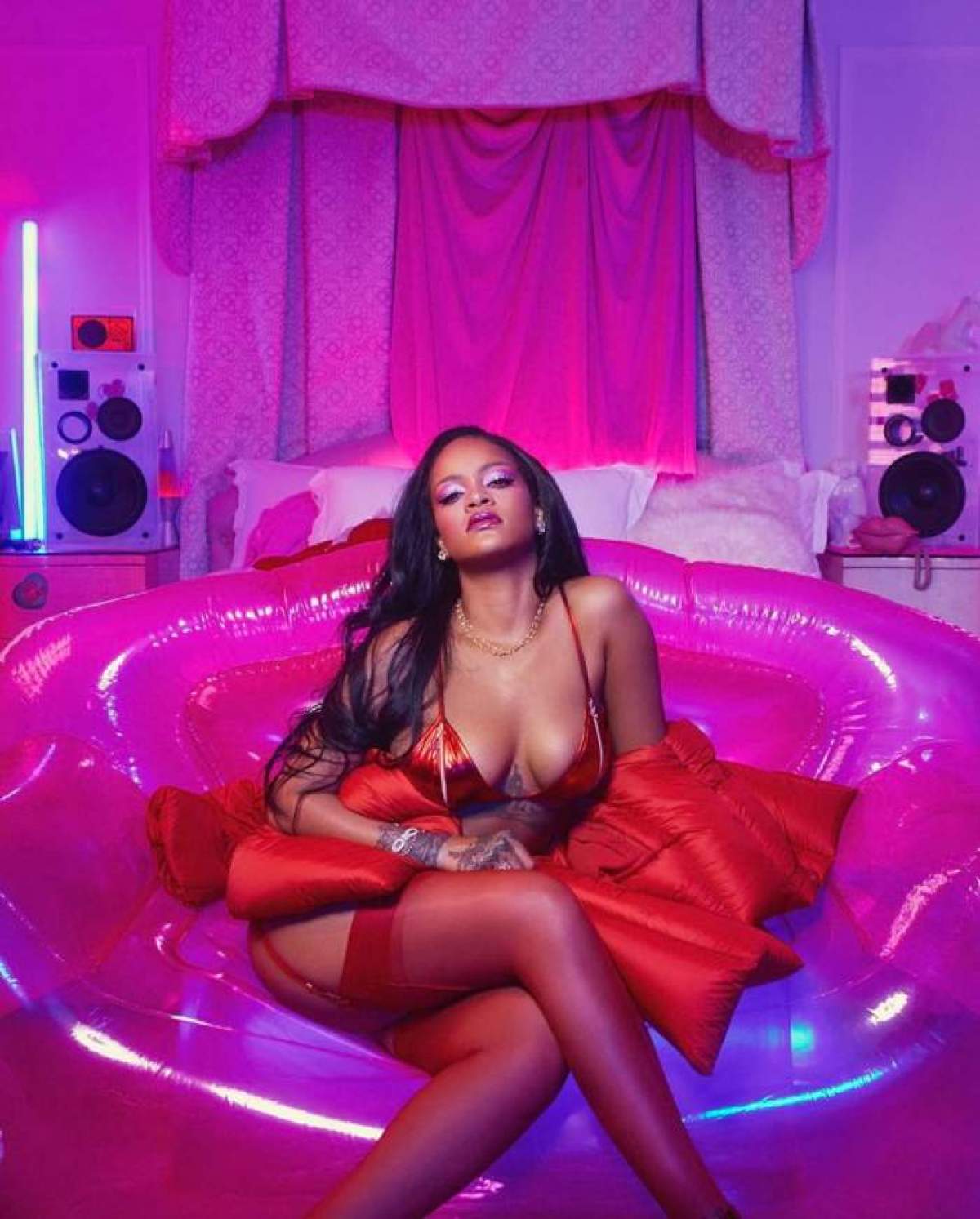 Rihanna este un lenjerie intima rosie si sta pe un fotoliu roz gonflabil
