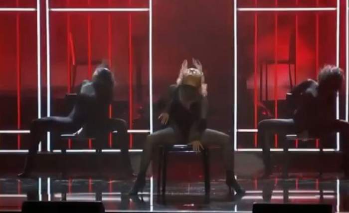 Jennifer Lopez a dansat senzual pe scenă, Artista stă pe scaun, cu picioarele desfăcute.