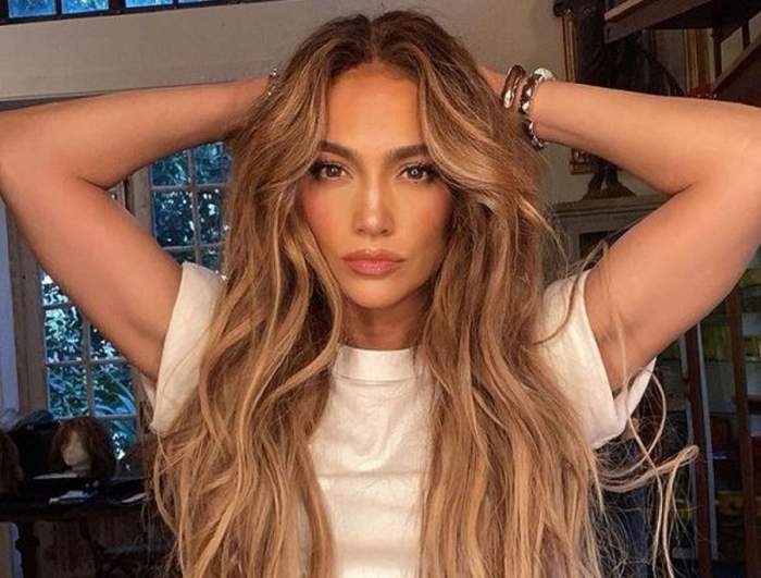 Jennifer Lopez poartă o perucă lungă. Artista e îmbrăcată cu un tricou alb.